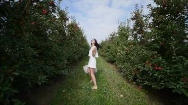 Güzel bir kız gider ve güneşli bir günde plantasyonunda görünüyor. Konsept: biyolojik ürünler, doğal ürünler, taze, lezzetli, meyve, sebze, büyümek, su, bitki, fotosentez