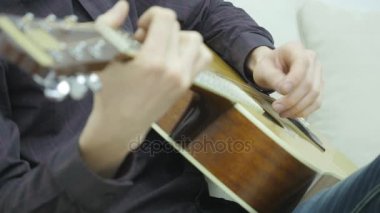 Yakın çekim, bir adamın elinde bir gitar çalmak