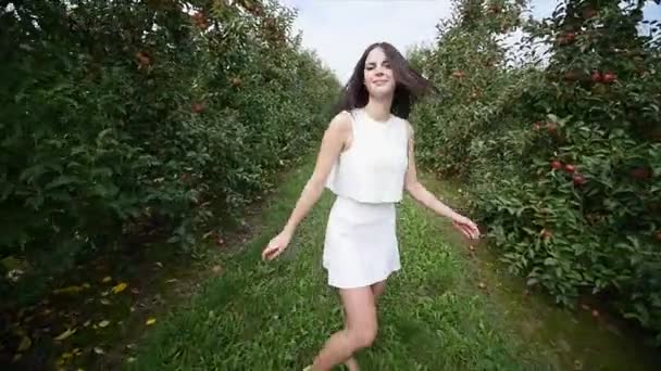 A beautiful girl goes and looks at the plantation, on a sunny day. Concept: bio products, natural products, fresh, delicious, fruits, vegetables, grow, water, plants, photosynthesis — Stock Video