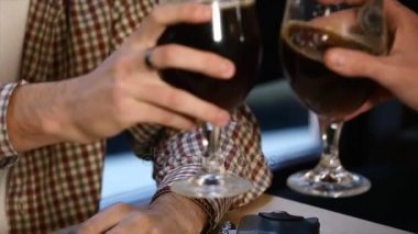 İki genç erkek arkadaş otururken bar ve birbirleri ile bira yudumlarken konuşuyor.