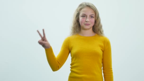 Felice sorridente bella giovane donna che mostra due dita o gesto di vittoria, isolato su sfondo bianco — Video Stock