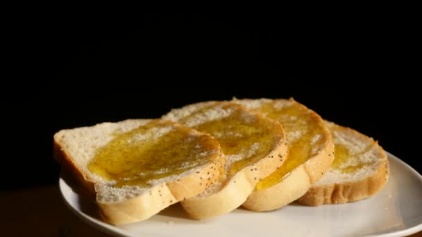Fatias de pão torrado com mel fluindo para baixo no fundo preto — Vídeo de Stock