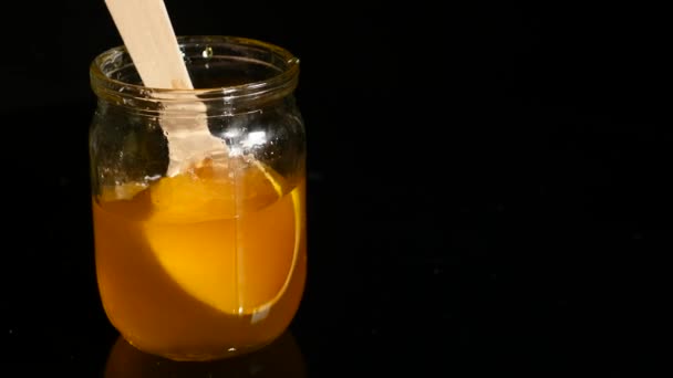 Lepel druipend van honing in een pot — Stockvideo