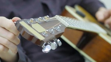 Yakın çekim, bir adamın elinde bir gitar çalmak