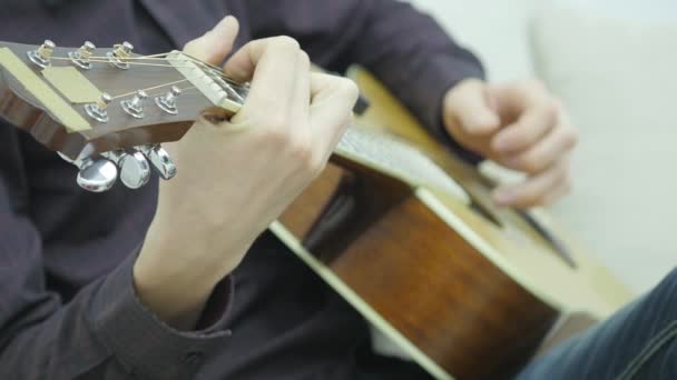 Närbild av en mans händer spelar en gitarr — Stockvideo