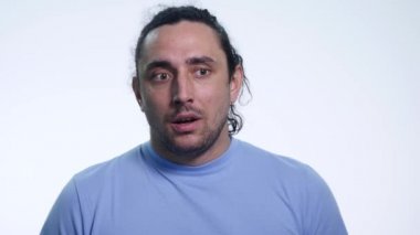 Beyaz arka plan üzerinde yapmak ne bilmiyorum bir poz T-gömlek yakışıklı duygusal adam portresi
