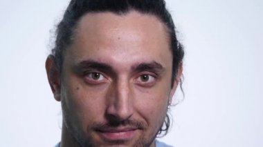 genç adam kamera ve Göz kırpmalar bakarak sakallı. yakın çekim