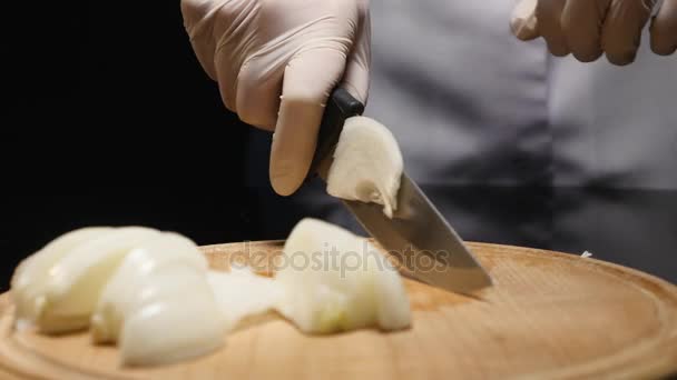 Chef cortando una cebolla con un cuchillo — Vídeos de Stock