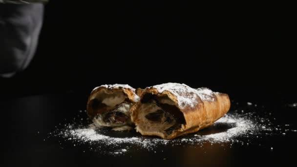 Verre de lait avec demi croissant sur fond noir. main met un verre de fond de lait — Video