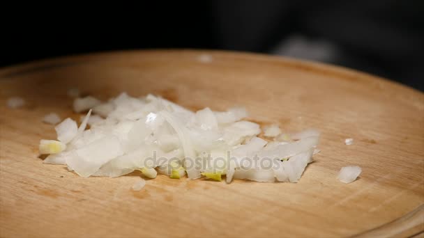 Cebolla picada sobre tabla de madera — Vídeo de stock