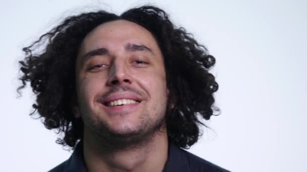 Ein Mann auf weißem Hintergrund lächelt und lacht in die Kamera — Stockvideo