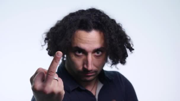 Portrait of a young man showing middle finger gesturing fuck on white background. close up. selective focus — Stockvideo