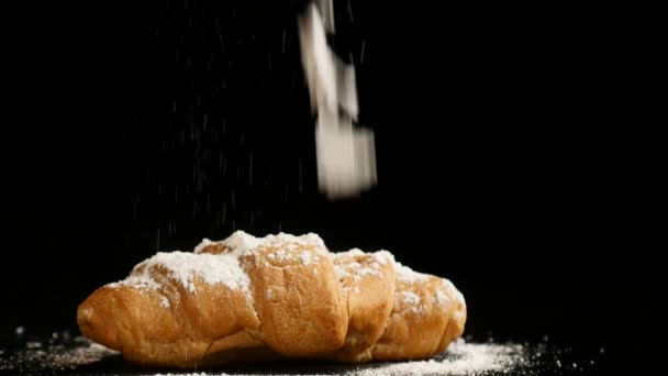 Azúcar en polvo espolvoreando en un croissant — Vídeos de Stock