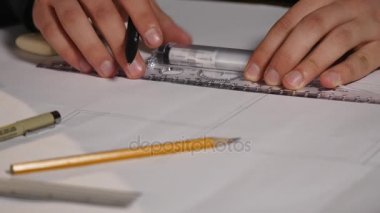 Adam mimar Ofis Masası, kağıt üzerine büyük kalem tarafından bir plan, grafik, tasarım, geometrik şekiller çizer. Siyah arka plan