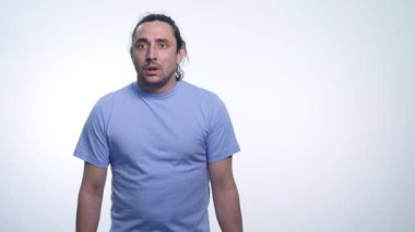 Beyaz arka plan üzerinde yapmak ne bilmiyorum bir poz T-gömlek yakışıklı duygusal adam portresi