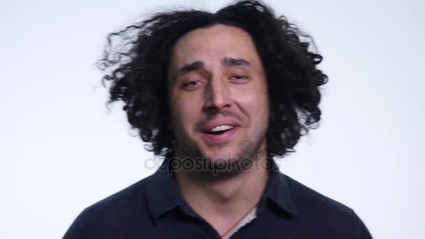 Carismático barbudo jovem em camisa preta no fundo branco mostra emoções diferentes — Vídeo de Stock