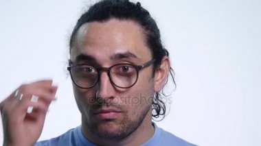 Yakışıklı adam. Güneş gözlüğü tutarak ve üzerinde beyaz izole ederken flört yakışıklı genç adam portresi. yakın çekim