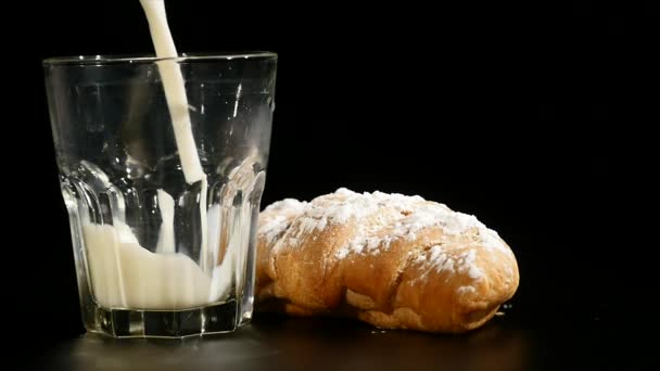 Verter la leche en un vaso largo sobre fondo negro — Vídeo de stock