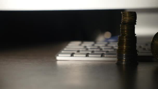 Close-up van een gouden bitcoin munt en munten op toetsenbord achtergrond — Stockvideo