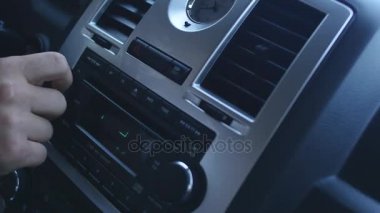 Araç radyosu, değişen istasyonları oynarken sürücü