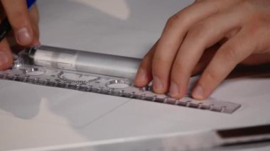 Adam mimar Ofis Masası, kağıt üzerine büyük kalem tarafından bir plan, grafik, tasarım, geometrik şekiller çizer. Siyah arka plan