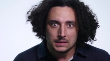 Beyaz arka planda siyah gömlekli karizmatik sakallı genç adam farklı duygular gösterir