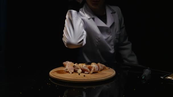 Ręka stawia cebulę i przyprawy na filet z kurczaka — Wideo stockowe