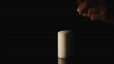 eller siyah arka plan üzerine bir mum yaktım