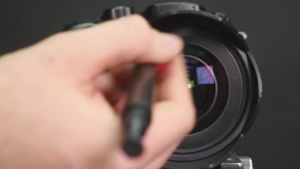 Ο φωτογράφος αναλαμβάνει τον καθαρισμό του φακού της κάμερας — Αρχείο Βίντεο