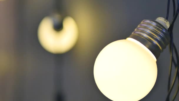 Light bulbs garland close up. Electric bulb shine hanging on wall as decoration for holiday close up — Stock Video