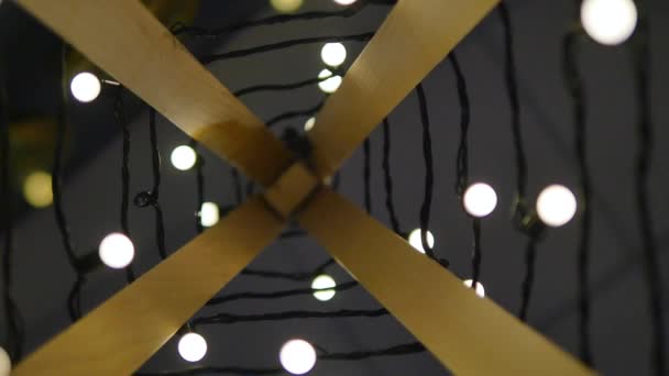 木製のクリスマス ツリー。ライトのガーランド。ビンテージ スタイルです。残りのぼかしでフィールドの電球の背景。党とモダンなカフェのデザイン コンセプト。木製のクリスマスのモダンな装飾のガーランド — ストック動画