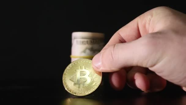 Bitcoin coin et les billets en dollars torsadés sur un fond noir — Video