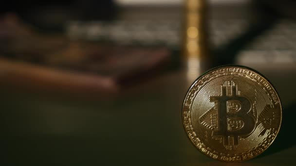 Κοντινό πλάνο χρυσή bitcoin κέρμα και νομίσματα στο πληκτρολόγιο και δολάρια τραπεζογραμμάτια φόντο. επιλεκτική εστίαση — Αρχείο Βίντεο