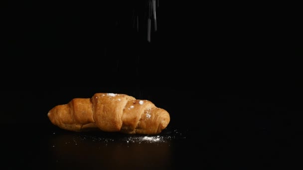 Azúcar en polvo espolvoreando en un croissant — Vídeos de Stock
