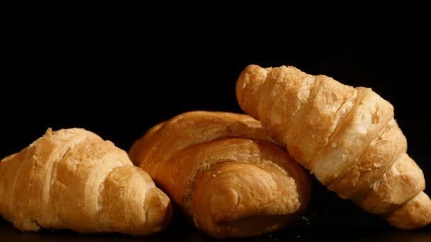 Three croissants on a black background — Stock Video