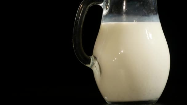 Jugful of milk isolated on black background — Stock Video
