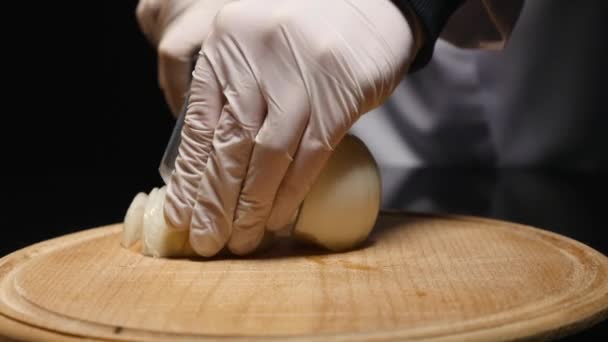 Chef cortando una cebolla con un cuchillo — Vídeo de stock