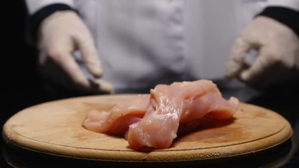 Ręce wyrzuca kawałki filet z kurczaka na pokładzie — Wideo stockowe