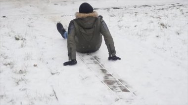 Genç şık giyinmiş adam kışın parkta yürüyüş kaydı ve dengesini kaybetti