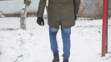 Genç şık giyinmiş adam kışın parkta yürüyüş kaydı ve dengesini kaybetti