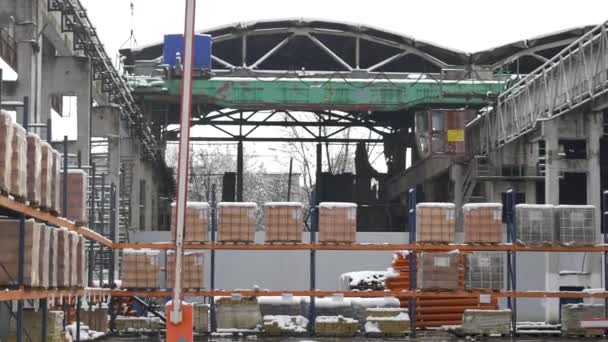 Materiales de construcción y construcción para la venta almacenados en estantes metálicos al aire libre en un patio de almacén junto con paletas de madera para carga, distribución y almacenamiento — Vídeos de Stock