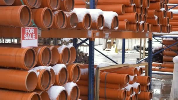 Oranje pvc leidingen gestapeld in bouwplaats — Stockvideo