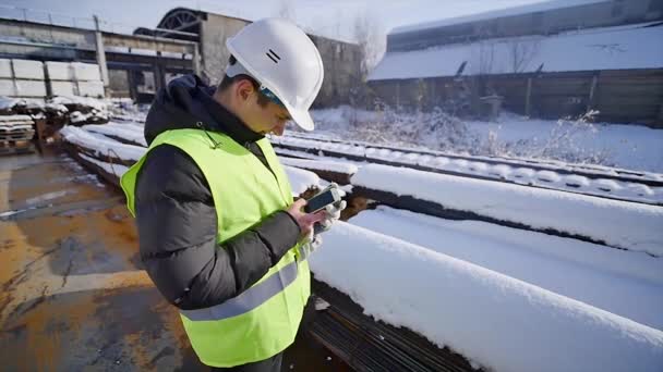 Stavební manažer procházení smartphone na stavební místo. — Stock video