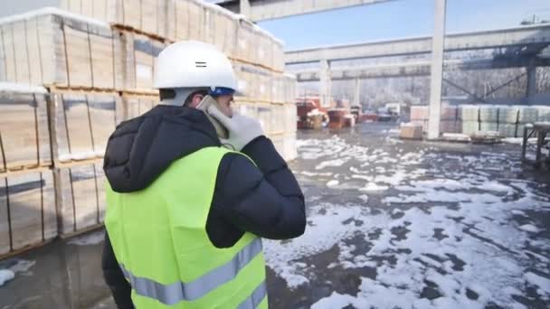 Industriële werknemer praten op mobiele telefoon in de fabriek voor de productie van levensmiddelen, de suikerfabriek — Stockvideo