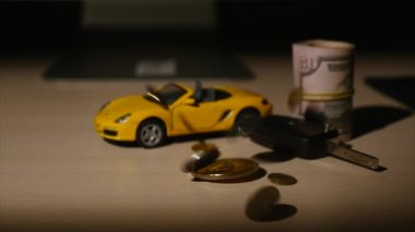 bitcoins paralar düşmek arka plan üzerinde küçük araba ve araba ve bükülmüş dolar anahtarları