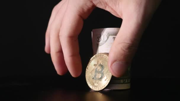 Moeda de Bitcoin e as notas de dólar torcidas em um fundo preto — Vídeo de Stock