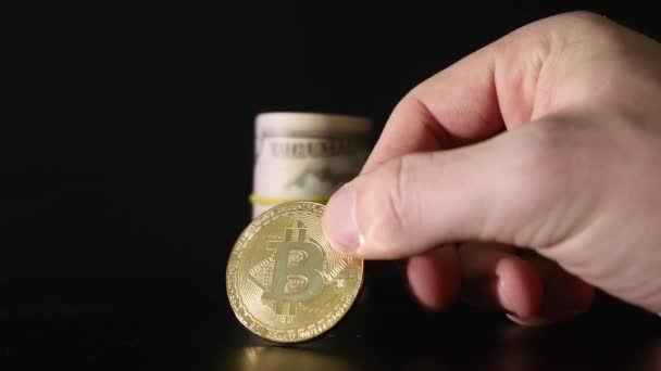 Bitcoin munten en de bankbiljetten van de gedraaide dollar op een zwarte achtergrond — Stockvideo