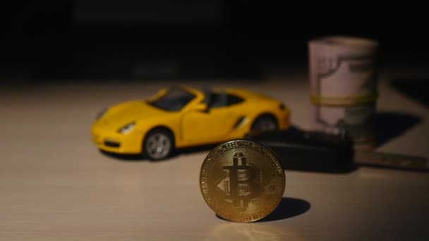 Bitcoins mynt med lite bil och nycklar från bilen och tvinnade dollar — Stockvideo