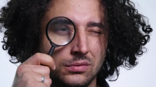 Young man looking through magnifying glass. close up — Stock Video