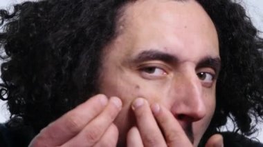 genç adam beyaz arka plan üzerinde bir sivilce sıkma. yakın çekim